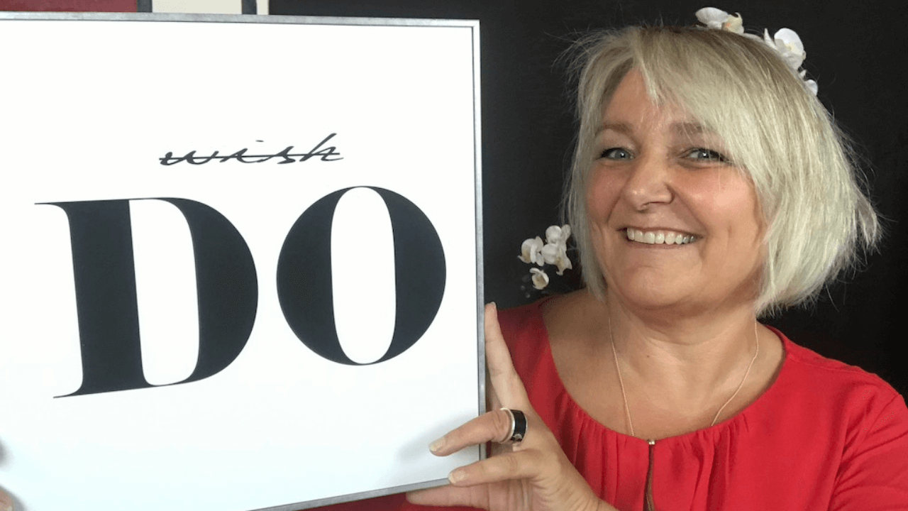 Katja Benny h&auml;lt ein Schild hoch, auf dem whish durchgestrichen ist und DO in Gro&szlig;buchstaben darunter steht.